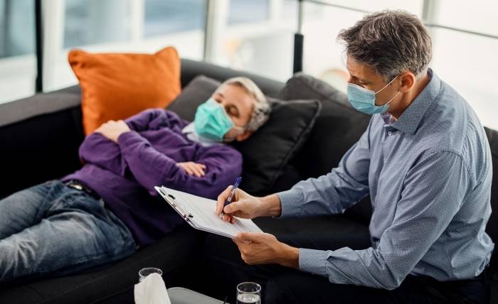 Why is Critical Illness Insurance a Lifesaver? mid adult psychiatrist writing notes while having therapy with male patient covid19 pandemic 637285 11146